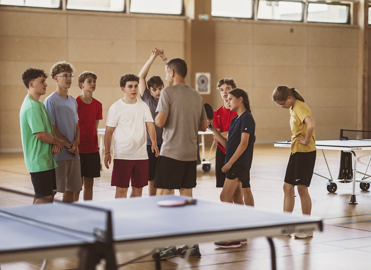 Élèves en cours d'EPS jouant au tennis de table